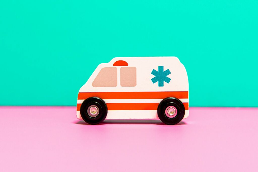 toy ambulance against bright pink and green background
